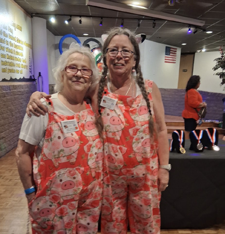 Two members in matching overalls pose in costume at the Clampett&rsquo;s Olympics